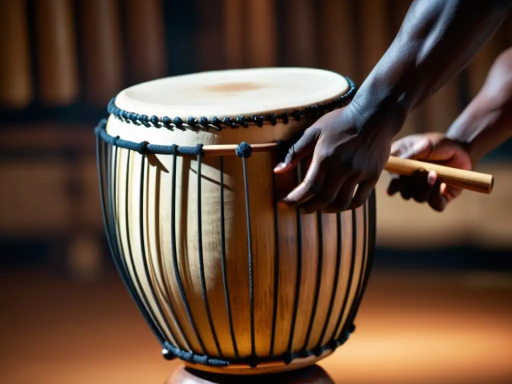 Un músico toca con pasión un tambor africano, resaltando la historia y sonido del talking drum